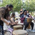 A group of adults and children playing the drums